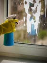 Person spraying window cleaning detergent