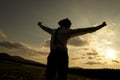 Person with spread arms in countryside sunset Royalty Free Stock Photo