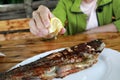 Person squeezes juice from lemon on grilled trout Royalty Free Stock Photo