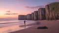 Person Standing on Beach at Sunset, Cliffs in the Background, Calm Waves Creating a Serene Atmosphere Royalty Free Stock Photo