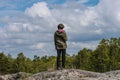 Person standing on cliffs looking out over a forest Royalty Free Stock Photo