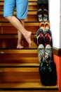 Person standing cross legged beside Different shoes on a staircase