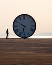 a person standing in front of a large clock Royalty Free Stock Photo