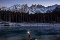Person standing by the Lake Carezza with Mount Latemar, Bolzano province, South Tyrol, Italy Royalty Free Stock Photo