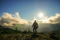 A Person Standing on the Mountain with Clouds During Sunset/Sunr