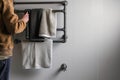 person standing near a wallmounted towel rack made of iron pipes Royalty Free Stock Photo