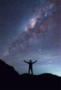 A person is standing next to the Milky Way galaxy spread hand on