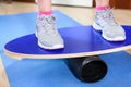 Person standing on oval wooden deck for balance, close up view