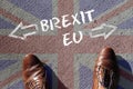 Person standing over UK flag with the words Brexit, EU in front of his shoes Royalty Free Stock Photo