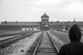 Person standing at Rail entrance to concentration camp Auschwitz Birkenau KZ Poland 2