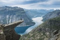 A person standing on the reef called trolltunga looking at the breathtaking view on norway lake and mountains.Norway famous place.