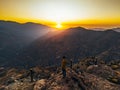 Person standing on a rock near hills at sunset in Farellones, Santiago, Chile