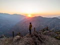 Person standing on a rock near hills at sunset in Farellones, Santiago, Chile