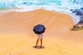 Person standing at the sandy beach with an umbrella in Bali, Indonesia Royalty Free Stock Photo