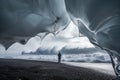 person standing on shore, icewave crests looming overhead