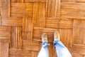 A person is standing on a wooden floor with a woven pattern Royalty Free Stock Photo