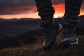 Person stands in hiking winter boots outdoors in front of the beautiful sunset Royalty Free Stock Photo