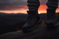 Person stands in hiking winter boots outdoors in front of the beautiful sunset Royalty Free Stock Photo