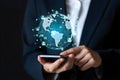 Businessman using smartphone with glowing digital globe and network connections overlay Royalty Free Stock Photo
