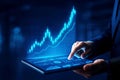 Person in suit pointing at a tablet displaying a rising blue financial graph and data analytics technology Royalty Free Stock Photo