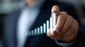 A person in a suit is pointing at a virtual bar chart. increasing bars from left to right, suggesting growth or progress. Royalty Free Stock Photo