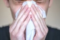 A person with symptoms of the disease presses a handkerchief to his face. Sneezing, bouts of coughing