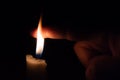 A person takes his finer into the candle flame. Burning in flame