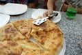 Person takes Megrelian Khachapuri from plate