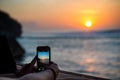 Person takes picture of sunset with their smartphone Royalty Free Stock Photo