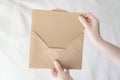Person taking a brown document out of the envelope Royalty Free Stock Photo
