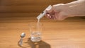 A person is taking an effervescent drug on a wood table