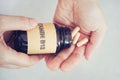 Person taking out Vitamin B12 pills out of bottle Royalty Free Stock Photo