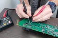 Person testing pcb by multimeter