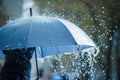 person testing umbrella durability in simulated rain