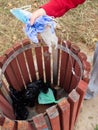 PERSON THROWING PANDEMIC WASTE INTO A TRASH CAN