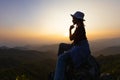 person on top of mountain, Silhouette of Young woman sitting on a rock looking to the horizon