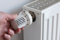 person turning down thermostat on heater to save energy Royalty Free Stock Photo