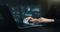 A person types on a laptop displaying translucent, futuristic digital interfaces.