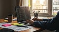 A person types on a laptop with a visible code editor open, suggesting