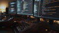 A person is typing on a keyboard in front of three computer monitors Royalty Free Stock Photo