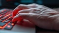 A person typing on a keyboard with red glowing keys, AI Royalty Free Stock Photo