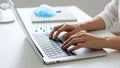 Person typing on laptop with cloud computing concept showing data transfer Royalty Free Stock Photo