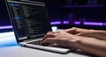 Person typing on laptop with code on screen in dark room Royalty Free Stock Photo