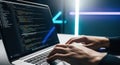 Person typing on laptop with code on screen in dark room Royalty Free Stock Photo