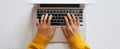 The person typing on a laptop in a cozy workspace with a yellow sweater. AI generated image Royalty Free Stock Photo