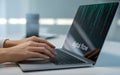 Person using a laptop displaying digital code on the screen Royalty Free Stock Photo