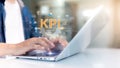 A person typing on a laptop with KPI and various digital icons representing data, analytics, and performance metrics displayed