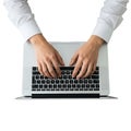 Person typing on a sleek silver laptop keyboard with focused hands on keys Royalty Free Stock Photo