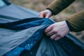 person unfolding a car cover to protect against future bird droppings