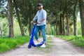 Person using blue electric scooter in the park